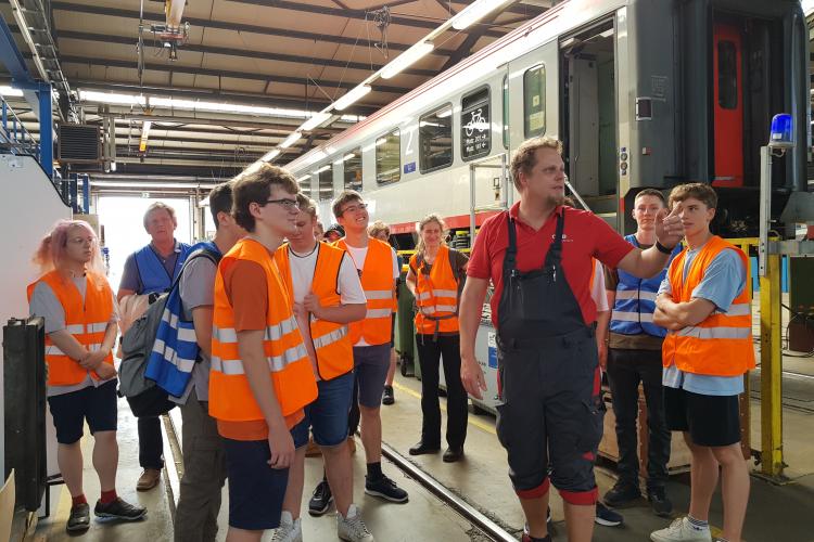 Gruppe besichtigt einen Zug in der Wekstatt